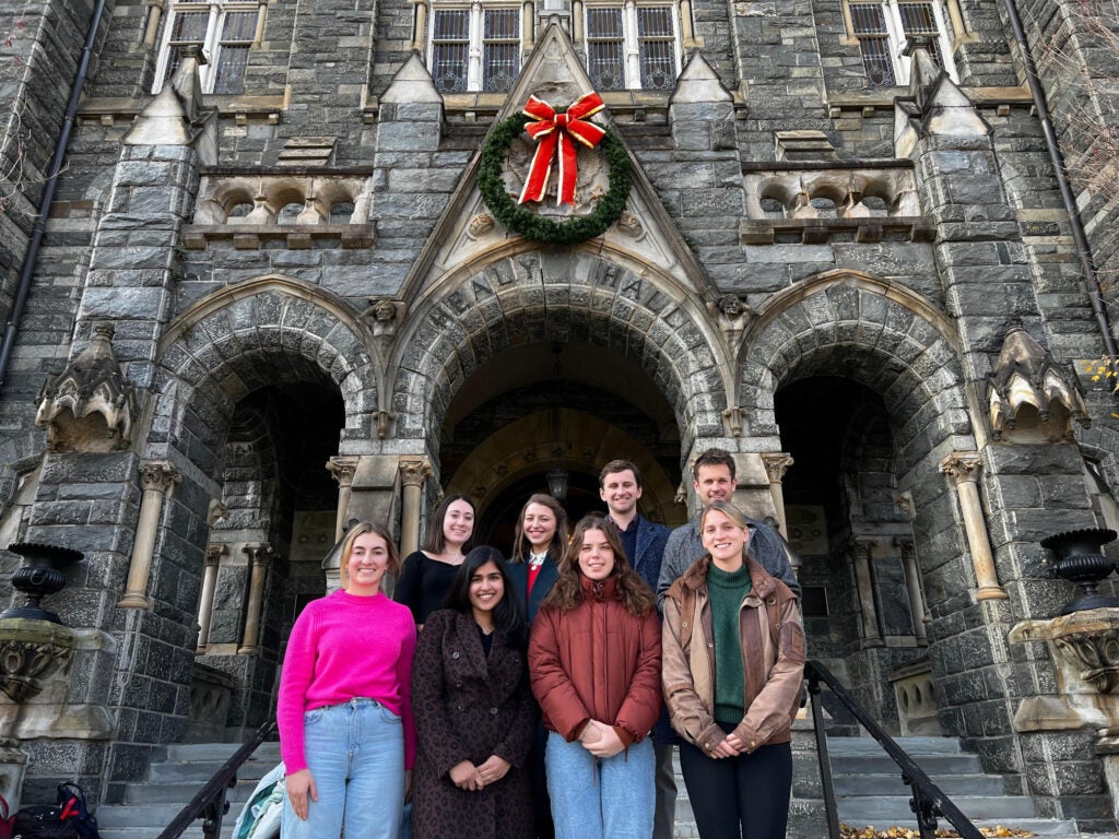 Image of all 8 Fellows standing in front of Healy Hall