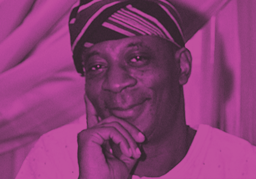 headshot of playwright bisi adigun in black and white. His face rests on his hand as he looks into the camera.